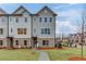 Beautiful three-story townhome with a well-manicured front lawn and a paved walkway at 1236 Ainsworth Aly # 37, Sugar Hill, GA 30518