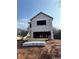 Exterior view of a framed two-story house under construction with visible building materials and open window spaces at 4862 Campbell Dr, Atlanta, GA 30349