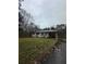 View of the house with a carport and a yard covered in leaves under a cloudy sky at 177 Weaver Cir, Canton, GA 30115