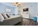 Light-filled bedroom with wood floors, ceiling fan, TV, white dresser, and metal bed frame at 2626 Peachtree Nw Rd # 804, Atlanta, GA 30305