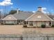 Rear view of home, showcasing its expansive layout, covered patios and landscaped yard at 6995 Polo Fields Pkwy, Cumming, GA 30040