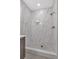 Elegant walk-in shower featuring marble-style tiling, river rock base, and black hardware at 129 Old Alabama Se Rd, Emerson, GA 30137