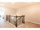 Upstairs hallway boasts decorative wrought iron railing, and plush carpet at 2882 Cadence Walk Rd, Atlanta, GA 30360