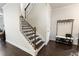 Staircase with hardwood steps, iron railings, and a convenient coat rack at 2882 Cadence Walk Rd, Atlanta, GA 30360