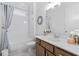 Bright bathroom with a shower-tub combo, white tile surround, and vanity with wood cabinets at 3750 Montebello Pkwy, Cumming, GA 30028