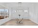 Bright dining room featuring a modern glass table, wood floors, and large windows offering ample natural light at 3750 Montebello Pkwy, Cumming, GA 30028