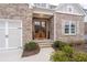 Inviting front entrance featuring a brick facade, double wooden doors, and manicured landscaping at 3750 Montebello Pkwy, Cumming, GA 30028