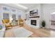 Bright living room featuring a fireplace, hardwood floors, large windows, and comfortable seating arrangement at 3750 Montebello Pkwy, Cumming, GA 30028