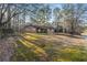 Exterior shot of home with grass lawn surrounded by tall trees at 1350 Piedmont Rd, Marietta, GA 30066