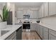 Kitchen with stainless steel appliances, gray cabinets, quartz counters, and tile backsplash at 320 Navigator Ln, Mcdonough, GA 30253