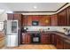 Updated kitchen boasts stainless steel refrigerator, microwave, granite countertops, and dark wood cabinets at 1650 Old Loganville Rd, Loganville, GA 30052