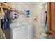 Well-organized laundry room with white washer and dryer, shelving, and ironing board at 1650 Old Loganville Rd, Loganville, GA 30052