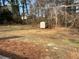 Large backyard with dormant lawn and trees in the background and a small shed for outdoor storage at 1666 Hearthstone Way, Jonesboro, GA 30236