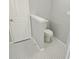 Bathroom featuring a toilet area separated by a half wall, tiled floor and a white door at 1666 Hearthstone Way, Jonesboro, GA 30236