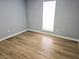 Bright bedroom featuring laminate floors, a large window, and neutral paint at 1666 Hearthstone Way, Jonesboro, GA 30236