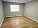 Bright bedroom featuring wood-look flooring, neutral walls, and a window with natural light at 1666 Hearthstone Way, Jonesboro, GA 30236