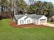 Exterior view of a well-maintained home with a two-car garage surrounded by lush landscaping at 1666 Hearthstone Way, Jonesboro, GA 30236