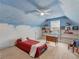 Attic bedroom painted with blue skies and white clouds featuring built-in shelving at 1000 Eddie Craig Dr, Mcdonough, GA 30252