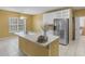 Well-lit kitchen featuring a kitchen island with sink, stainless refrigerator, and white cabinetry at 1000 Eddie Craig Dr, Mcdonough, GA 30252