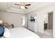 Bedroom with trey ceiling, neutral decor, bedside tables and a peak into the Primary bath at 4220 Cavalier Way, Duluth, GA 30097