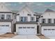 Beautiful two-story townhomes with white brick and two-car garages with covered entrance at 4220 Cavalier Way, Duluth, GA 30097