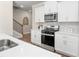 Modern kitchen with stainless steel gas range, white cabinets, and quartz countertops at 4220 Cavalier Way, Duluth, GA 30097