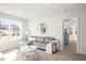 Relaxing living room featuring a plush gray sofa, round mirror, and natural lighting at 4220 Cavalier Way, Duluth, GA 30097