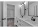 This bathroom vanity features double sinks, black faucets and a rectangular framed mirror at 131 Old Alabama Se Rd, Emerson, GA 30137