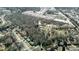 Wide aerial shot featuring lush trees and houses in a quiet neighborhood bordering commercial buildings at 116 Thornton Dr, Jonesboro, GA 30236