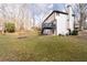 Large grassy backyard with a blue deck, fire pit, and mature trees at 2321 Birdie Ln, Duluth, GA 30096