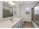 Well-lit bathroom featuring a large mirror, a shower with glass door, and a window at 2321 Birdie Ln, Duluth, GA 30096