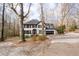 View of home from driveway showing well manicured lawn with mature trees at 2321 Birdie Ln, Duluth, GA 30096