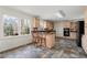 Bright kitchen features light wood cabinets, black appliances, and a window offering a view of the surrounding greenery at 2321 Birdie Ln, Duluth, GA 30096