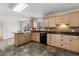 Open kitchen with light wood cabinets, tile flooring, black appliances, and center island at 2321 Birdie Ln, Duluth, GA 30096