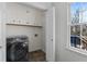 Laundry room boasts upper cabinets, gray front load washer, and natural light at 2321 Birdie Ln, Duluth, GA 30096