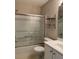 Bathroom features a shower-tub combination with sliding glass doors and a circular shelving unit at 2394 Elkhorn Ter, Duluth, GA 30096