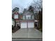Traditional style townhouse with two-car garage and a brick and siding exterior at 2394 Elkhorn Ter, Duluth, GA 30096