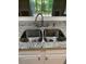 The stainless steel kitchen sink features granite countertops and white cabinets at 2394 Elkhorn Ter, Duluth, GA 30096