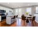 Stylish kitchen featuring stainless steel appliances, eat-in island, and a dining area with modern chairs at 11338 Musette Cir, Alpharetta, GA 30009