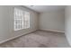 Neutral bedroom featuring a large window and plush carpet at 3174 Palm Tree Dr, Lithonia, GA 30038