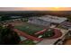 Aerial view of Johns Creek High School football field surrounded by trees at sunset at 608 Goldsmith Ct # 113, Johns Creek, GA 30022