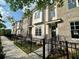 Attractive brick townhomes with black metal fences, sidewalk, and manicured landscaping at 608 Goldsmith Ct # 113, Johns Creek, GA 30022