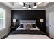 Main bedroom with large window, tray ceiling and decorative black accent wall at 608 Goldsmith Ct # 113, Johns Creek, GA 30022