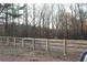 Property border featuring a wooden fence, trees, and dead leaves at 7382 Knox Bridge Hwy, Canton, GA 30114