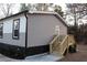 A rear view of the home features a wooden deck with stairs at 7382 Knox Bridge Hwy, Canton, GA 30114