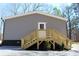 Charming gray home featuring a wooden staircase leading to a white door and vinyl siding at 7382 Knox Bridge Hwy, Canton, GA 30114