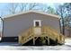 Exterior view showcasing the home's gray siding and wooden stairs to the back door at 7382 Knox Bridge Hwy, Canton, GA 30114