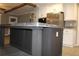 Kitchen island with gray cabinetry and countertop, with modern refrigerator and microwave in background at 7382 Knox Bridge Hwy, Canton, GA 30114