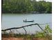 A serene lake view with lush trees and a fisherman in a boat for outdoor activities at 7382 Knox Bridge Hwy, Canton, GA 30114