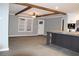 Open living room with wood beam ceiling and grey walls adjoining modern kitchen at 7382 Knox Bridge Hwy, Canton, GA 30114